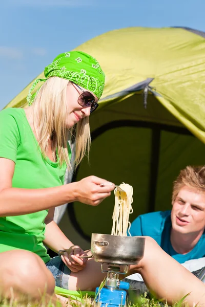 Молодая пара кемпинга готовит еду снаружи палатки — стоковое фото