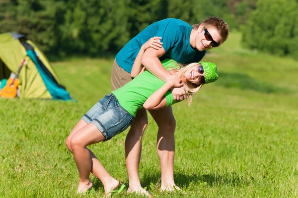 Νεαρό ζευγάρι κάμπινγκ που αγκαλιάζει στην εξοχή το καλοκαίρι — Φωτογραφία Αρχείου