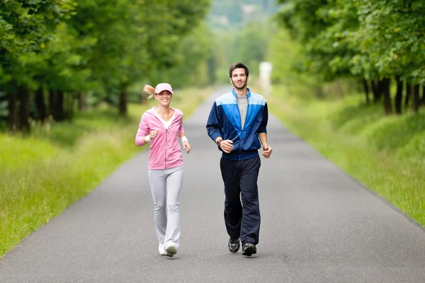 运行公园路的慢跑运动年轻夫妇 — 图库照片
