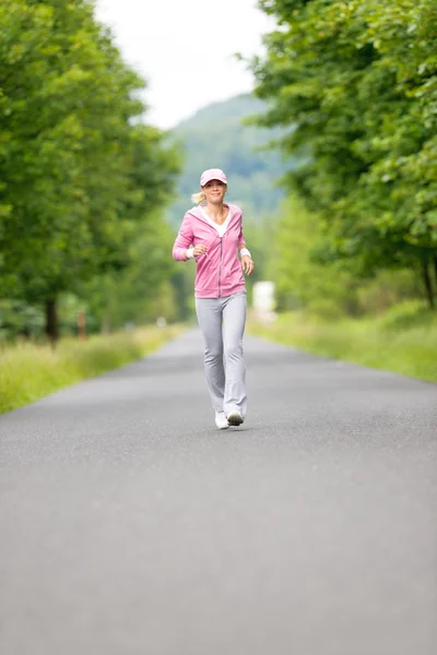 Jogging sportig unga kvinna kör park road — Stockfoto