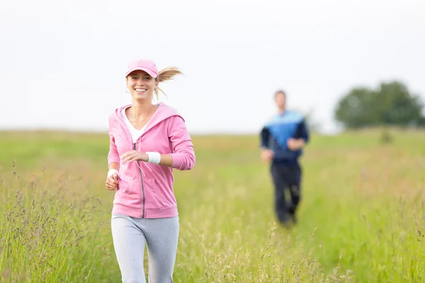 Jogging sportive young couple running meadow field — Stock Photo, Image