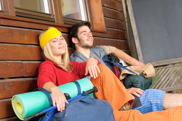 Tramping jovem casal mochila dormir por casa de campo — Fotografia de Stock