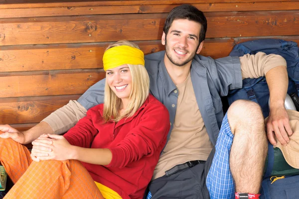 Jak mladý pár batoh relaxovat u chaty — Stock fotografie