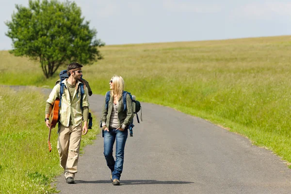Hiking young couple backpack tramping asphalt road — Stock Photo, Image