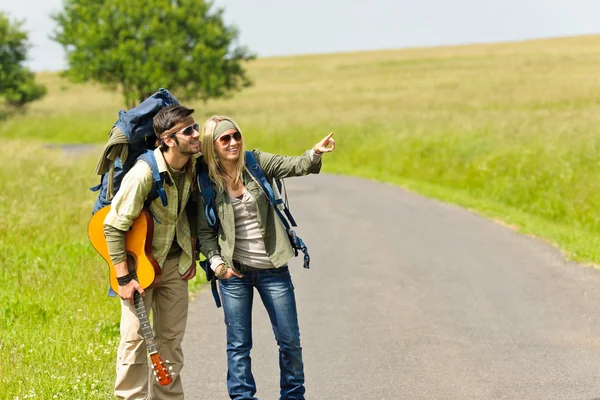 Turystyka młoda para plecak tramping droga asfaltowa — Zdjęcie stockowe