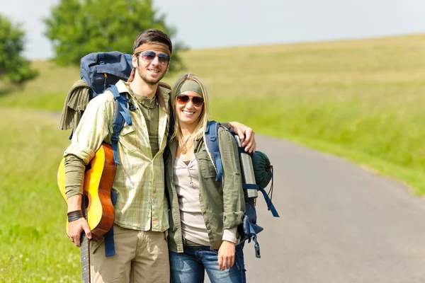 Genç çiftin sırt çantası derbeder asfalt yol hiking — Stok fotoğraf