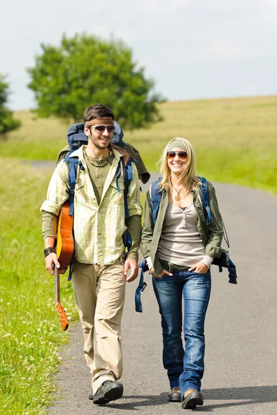 徒步旅行的年轻夫妇背包踩沥青路面 — 图库照片