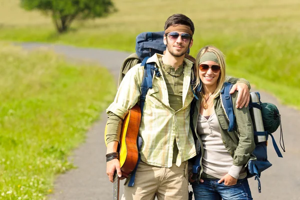 Fiatal pár hátizsák csavargóélet aszfaltúton túrázás — Stock Fotó