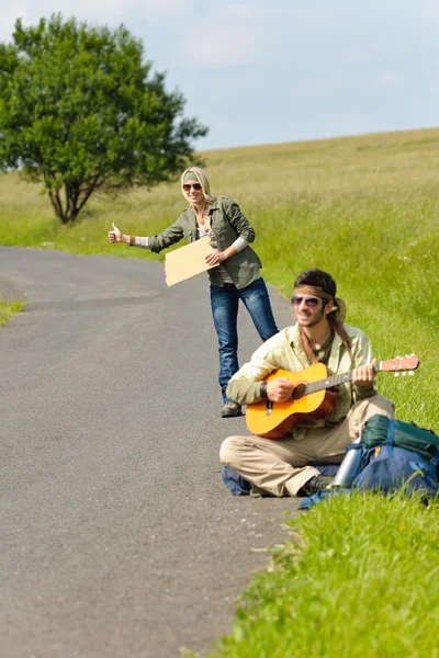 Hitch-hiking jovem casal mochila estrada asfalto — Fotografia de Stock