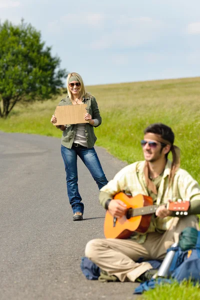 Hitch-randonnée jeune couple sac à dos route asphaltée — Photo