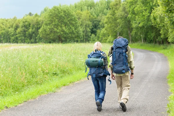 Yürüyüş genç çiftin sırt çantası asfalt karayolu kırsal — Stok fotoğraf