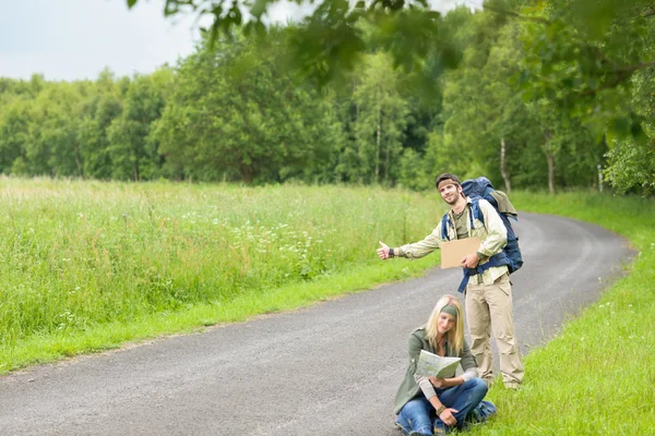 Hitch-hiking young couple backpack asphalt road — Stock Photo, Image