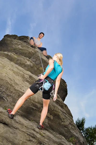 女性岩男を登るロープを保持します。 — ストック写真