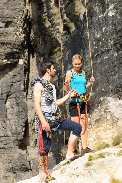 Escalada en roca joven hombre mostrando mujer cuerda —  Fotos de Stock