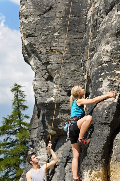 Rock escalada macho instrutor loira mulher ensolarada — Fotografia de Stock
