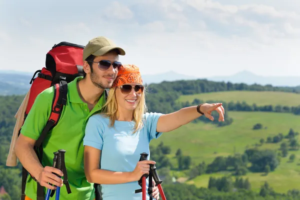 Wanderndes junges Paar zeigt auf Panoramablick — Stockfoto