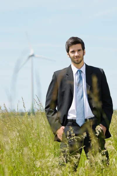 Green energy - Young businessman in field windmill — Stock Photo, Image
