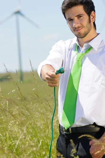 Zelená energie podnikatel v poli drží plug — Stock fotografie