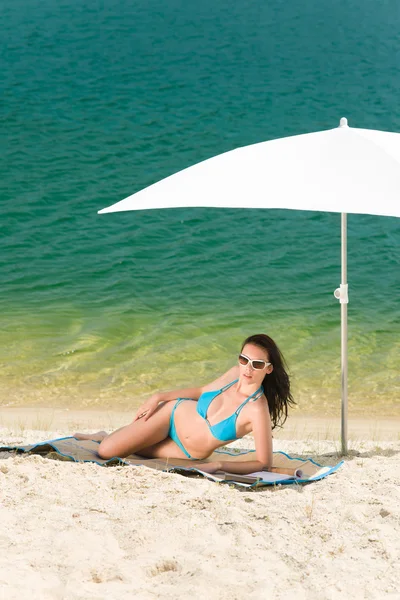 Summer beach woman blue bikini under parasol Stock Photo