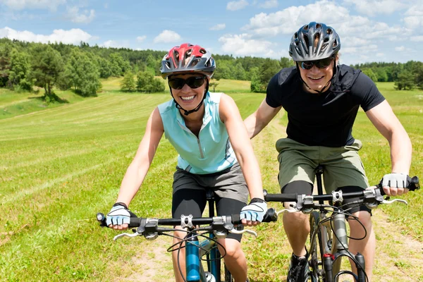 运动山地自行车-男人推年轻女孩 免版税图库照片