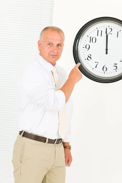 Punctual businessman mature point at clock — Stock Photo, Image