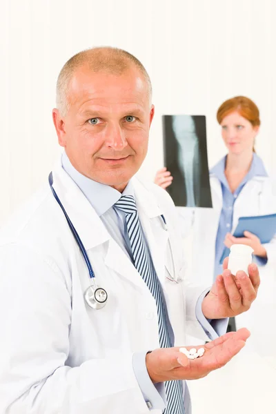 Médico equipe médico macho sênior segurar pílulas — Fotografia de Stock