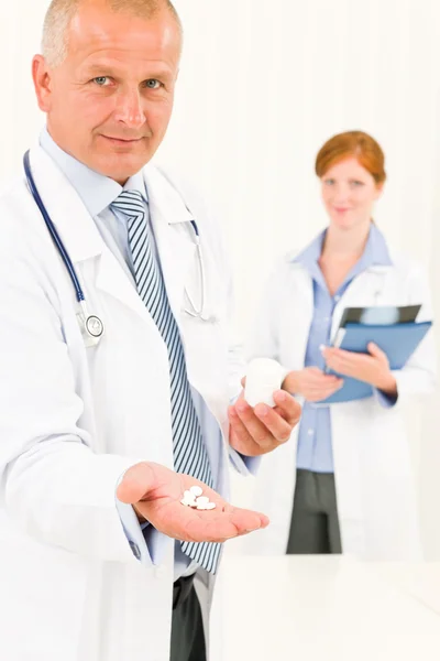 Медична команда лікаря старший чоловік тримає таблетки — стокове фото