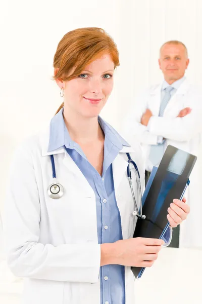Lekarz zespołu młoda kobieta trzymać x-ray — Zdjęcie stockowe