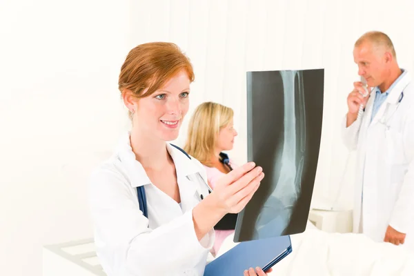 Artsen kijken x-ray patiënt gebroken arm — Stockfoto