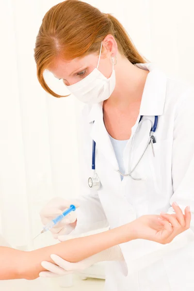 Vrouwelijke arts toepassing injectie aan patiënt — Stockfoto
