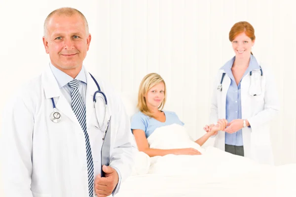 ベッドに横たわっている患者と医師二人 ストック画像