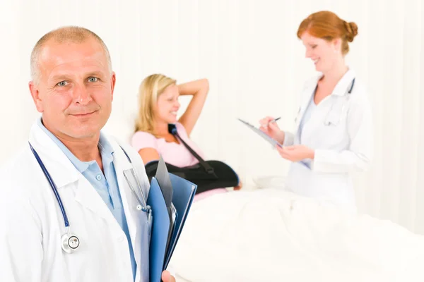 Läkare med patienten liggande sjukhussäng Stockfoto