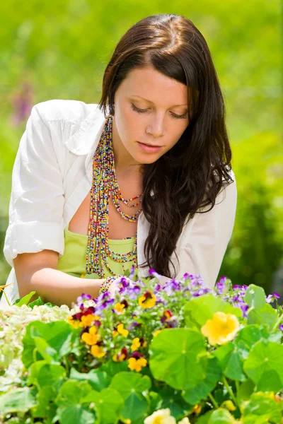 Літній сад красива жінка догляд за кольоровими квітами — стокове фото