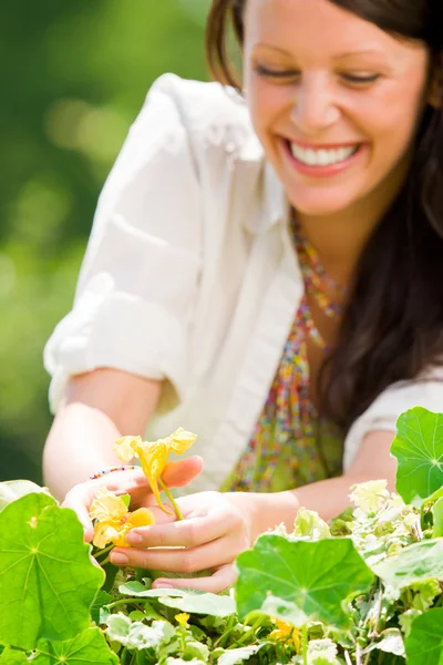Zomer tuin mooie vrouw die lacht zorg bloem — Stockfoto