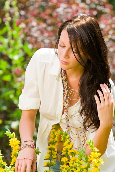 Красива жінка сонячний догляд за садом жовті квіти — стокове фото