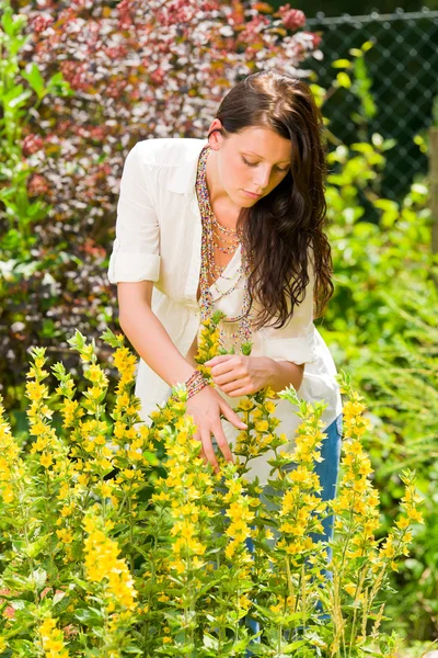Hermosa mujer soleado jardín cuidado flores amarillas —  Fotos de Stock