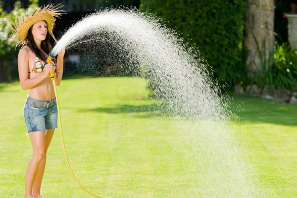 Verão jardim mulher brincar com mangueira de água — Fotografia de Stock