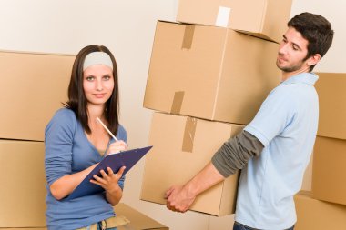Moving home young couple carrying cardboard boxes clipart