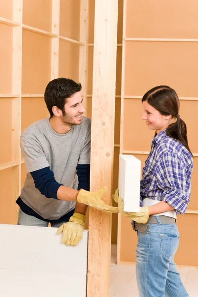 Hem förbättring ungt par bygga tegelvägg — Stockfoto