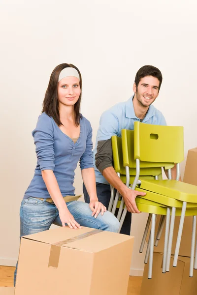 Moving new home young couple carry chairs — Stock Photo, Image