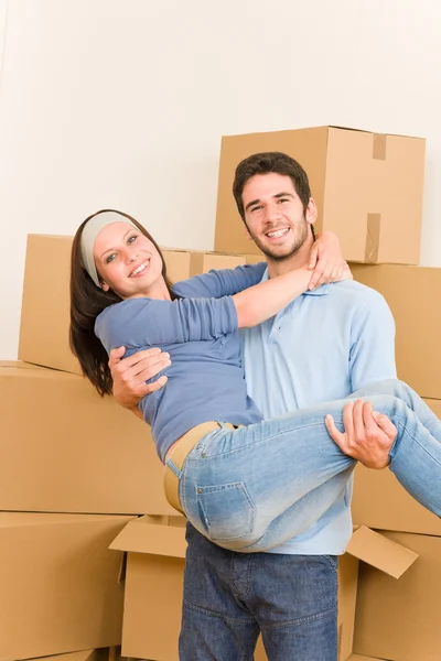 Mover nuevo hogar joven hombre sosteniendo mujer — Foto de Stock