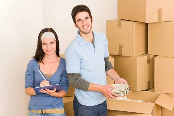 Переїзд додому молода щаслива пара розпаковує коробки — стокове фото