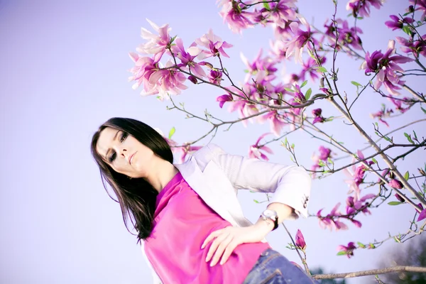 Menina na moda e flores roxas — Fotografia de Stock