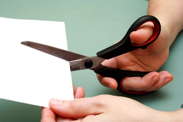 Women hand cutting paper with scissors — Stockfoto