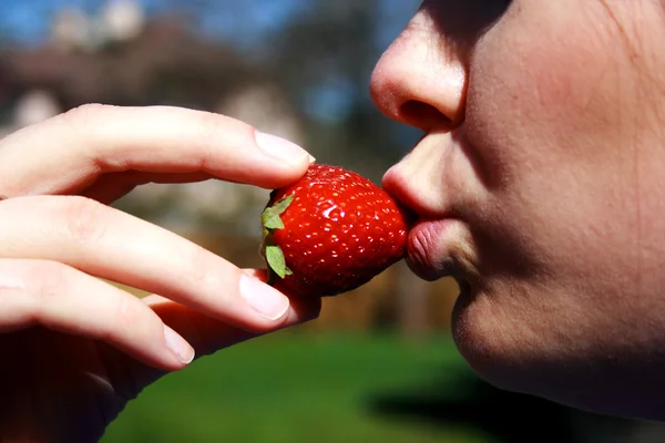 Gesicht der Frau, die eine Erdbeere isst — Stockfoto