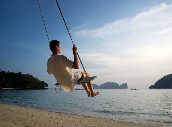 Junger mann auf strand schaukel phi phi thailand — Stockfoto