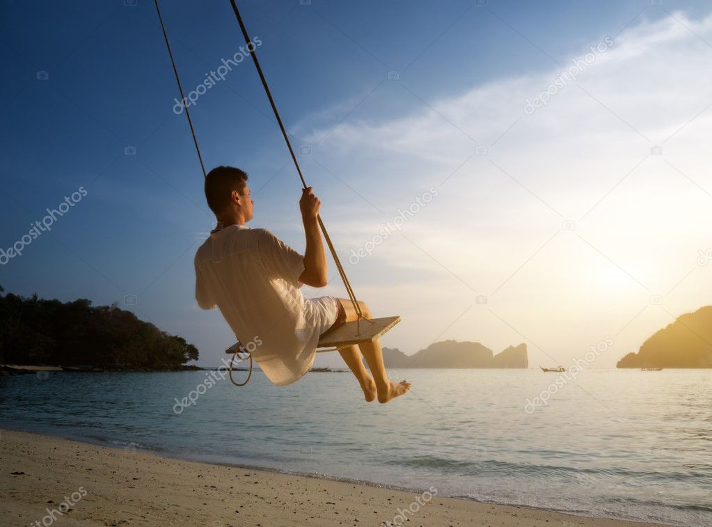 Young man on beach swing Phi Phi Thailand