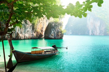 Long boat on island in Thailand clipart