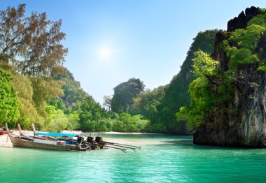 Long boats on island in Thailand clipart