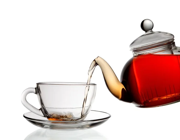 Tee wird in Glas Teetasse isoliert auf weißem Hintergrund gegossen — Stockfoto
